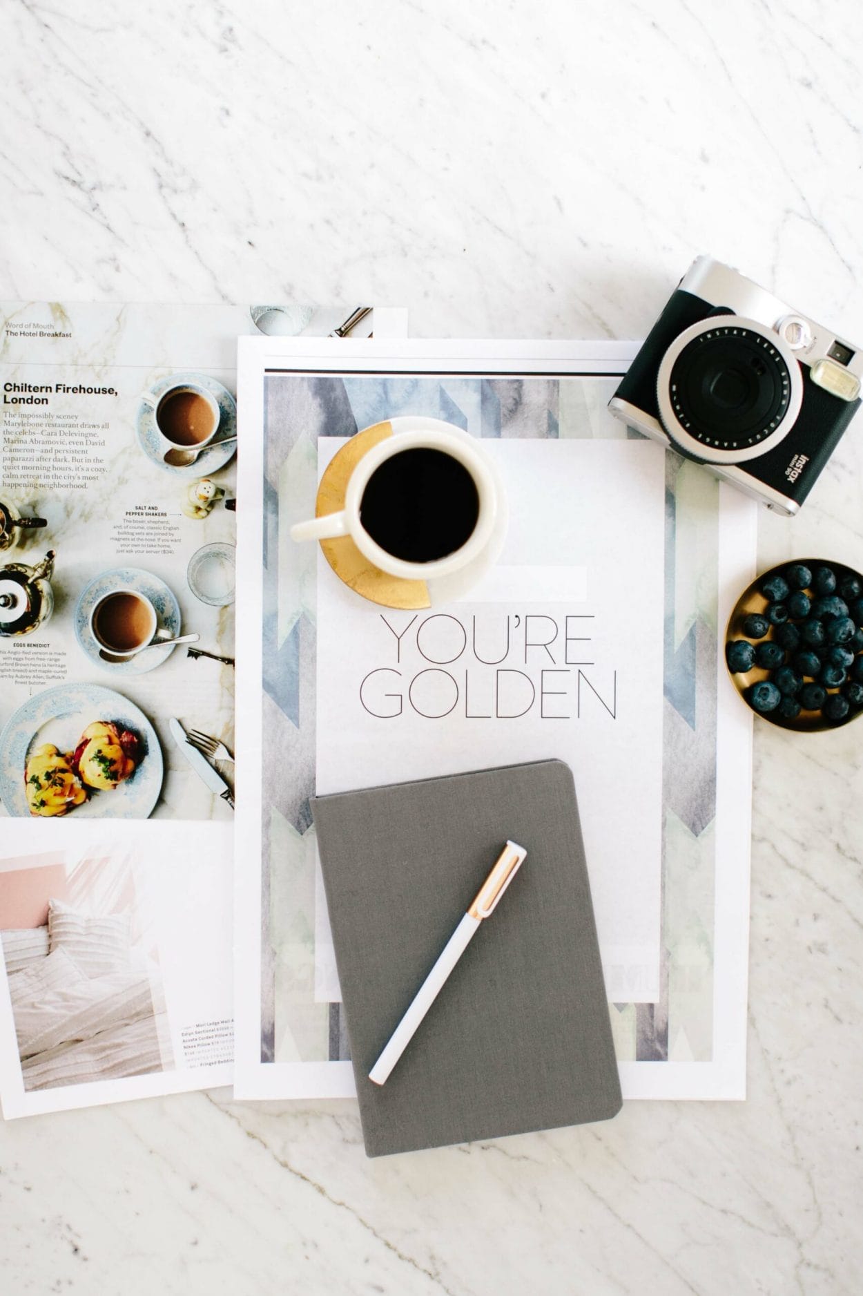  Flatlay featuring a modern black and white coffee cup with the text "Your Golden Quote" and assorted magazines.